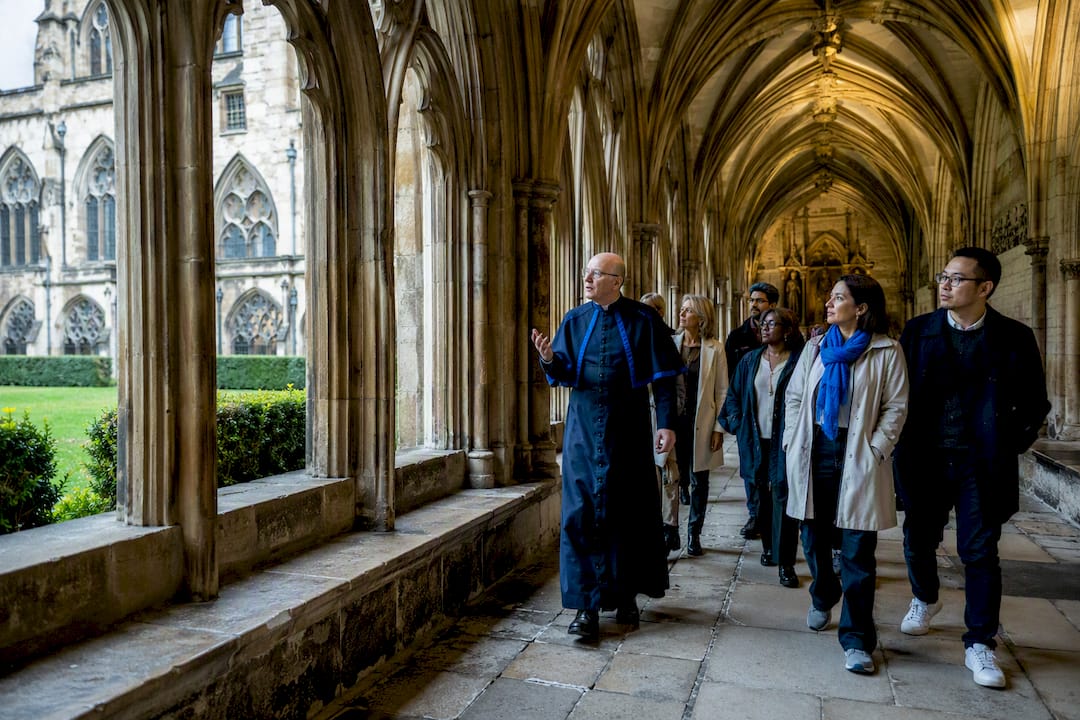 Verger leading visitors through Abbey cloister