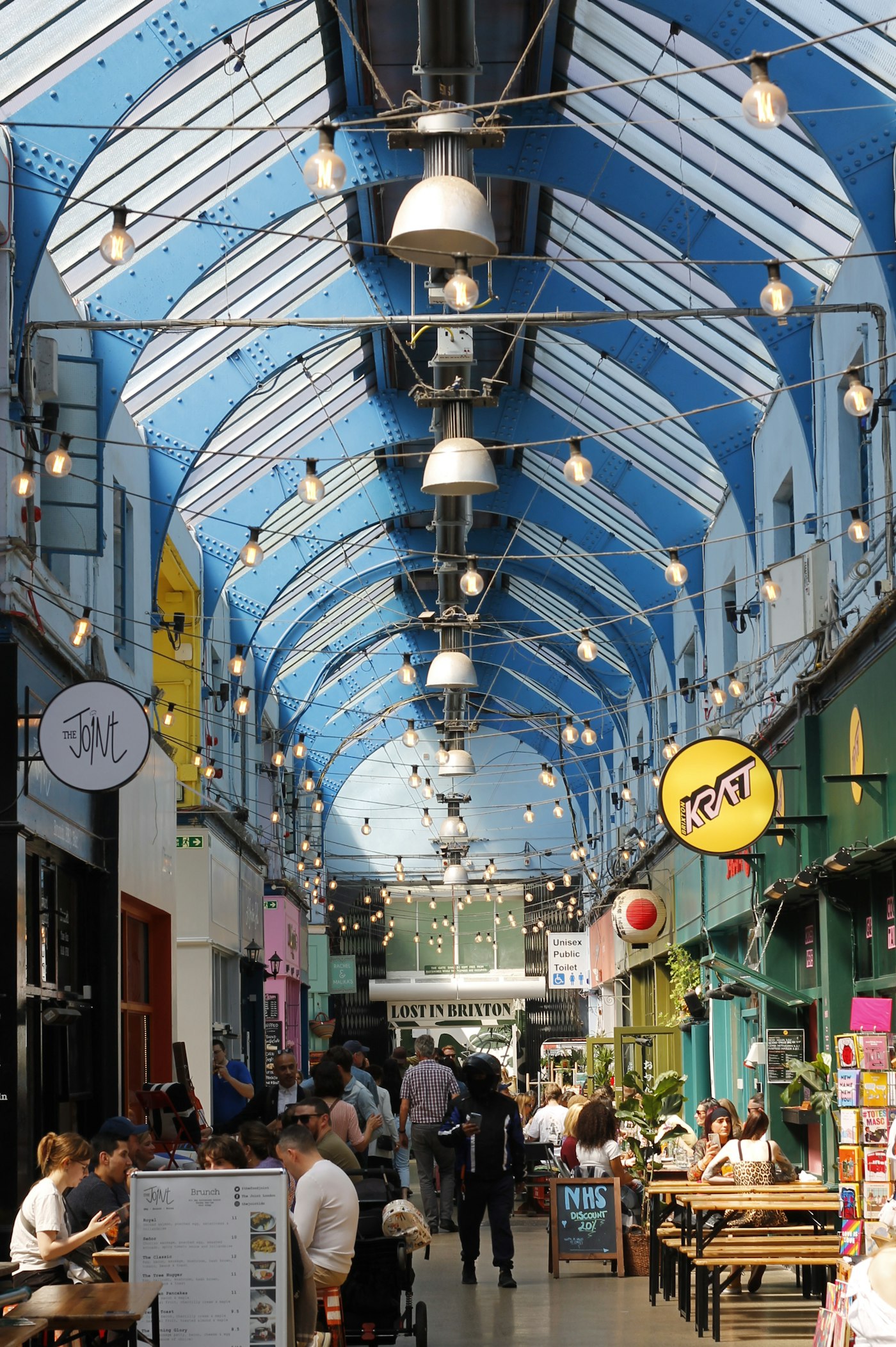 Brixton Village covered market with colourful stalls and diners south London